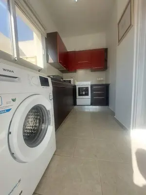 a washing machine in a kitchen with red cabinets at Central 1 bedroom lux apartment in Larnaka