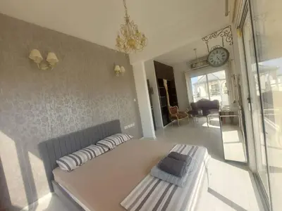 a living room with a couch and a clock on the wall at Central 1 bedroom lux apartment in Larnaka