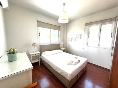 a small bedroom with a bed and two windows at Hephaestus Family Villa, Ayia Triada Beach in Paralimni