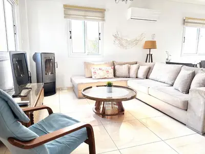 a living room with a couch and a table at Hephaestus Family Villa, Ayia Triada Beach in Paralimni