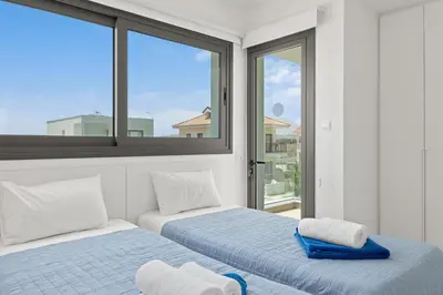 two beds in a room with two windows at Serenity Waves Villa 21 in Sophtadhes