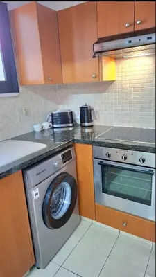 a kitchen with a washing machine and a washer at By The Way Apartment 1 in Larnaka
