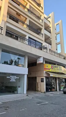 an apartment building with a parking lot in front of it at By The Way Apartment 1 in Larnaka