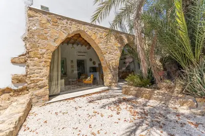 a stone house with a window and a palm tree at 1927 Heritage House - Indoor Garden , Old City in Nicosia