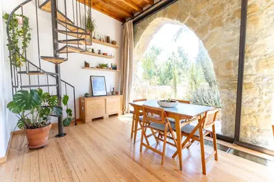 a dining room with a table and a spiral staircase at 1927 Heritage House - Indoor Garden , Old City in Nicosia