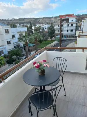 a table and chairs on a balcony with a table and flowers at Oroklini, Cyprus in Voroklini