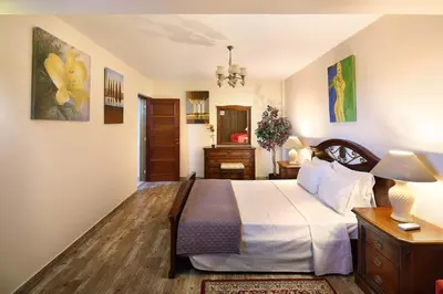 a bedroom with a bed and a dresser in it at Olive Tree Apartments in Limassol