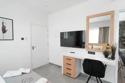 a bedroom with a desk with a mirror and a chair at Kition Urban Suite 2 in Larnaka