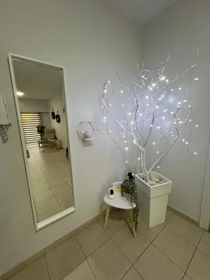 a bathroom with a tree with lights on the wall at Tower Court rooms in Larnaka