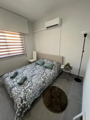a bedroom with a bed and a table and a window at Tower Court rooms in Larnaka