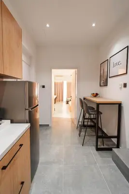 a kitchen with a table and a refrigerator at Kition Urban Suite 1 in Larnaka