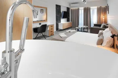 a hotel room with a bed and a bathroom at Kition Urban Suite 1 in Larnaka