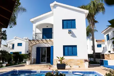 a villa with a swimming pool in front of a house at Villa Alexander The Great in Protaras