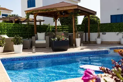 a swimming pool with a wooden gazebo and a swimming pool at Villa Alexander The Great in Protaras