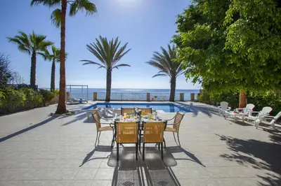 a dining table and chairs with a view of the ocean at Luxury Villa With Special Sea Views in Meneou