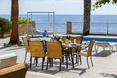 a table and chairs with the ocean in the background at Luxury Villa With Special Sea Views in Meneou