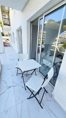 a picnic table and a chair on a patio at Urban Comfort Apartment in Larnaka
