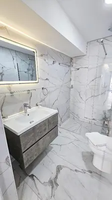 a white bathroom with a sink and a toilet at Urban Comfort Apartment in Larnaka