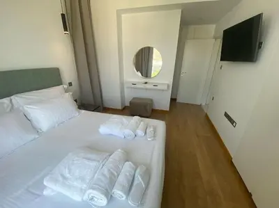a bedroom with a bed with towels and a mirror at The Address -Beachfront 2 Bedroom Residence in Limassol
