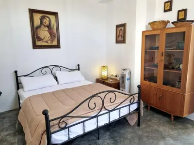 a bedroom with a bed and a wooden cabinet at Villa Christothea in Paphos