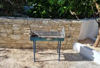 a grill sitting in front of a stone wall at Villa Christothea in Paphos