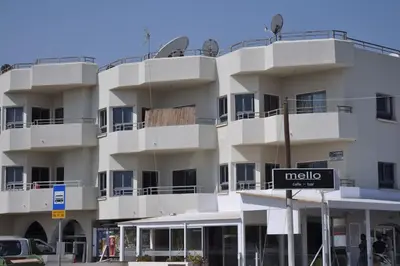 a white building with a sign in front of it at Niove Budget One-Bedroom Apartment in Paralimni