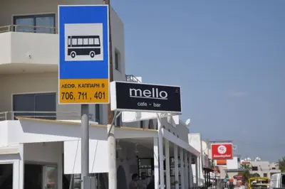 a street sign in front of a building with a bus at Niove Budget One-Bedroom Apartment in Paralimni