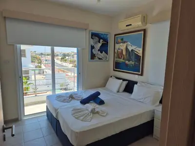 a bedroom with a bed with a large window at Villa Amaryllis in Paralimni