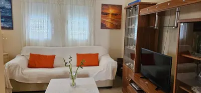 a living room with a white couch and a television at Villa Amaryllis in Paralimni