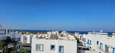 a group of white buildings with the ocean in the background at Villa Amaryllis in Paralimni