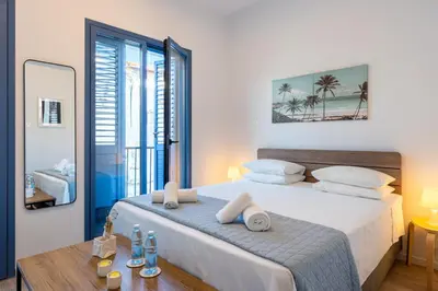 a bedroom with a bed and a table with towels on it at Le Voyageur By the Sea - Furnished Rooms in Larnaka