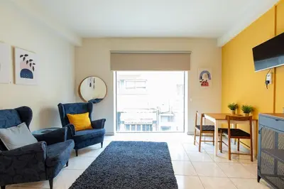 a living room with a table and chairs at Charming studio with reading nook & city view in Nicosia