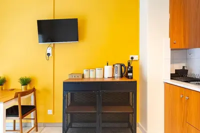 a kitchen with a counter with a yellow wall at Charming studio with reading nook & city view in Nicosia