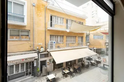 a view from a window of a street with tables at Charming studio with reading nook & city view in Nicosia