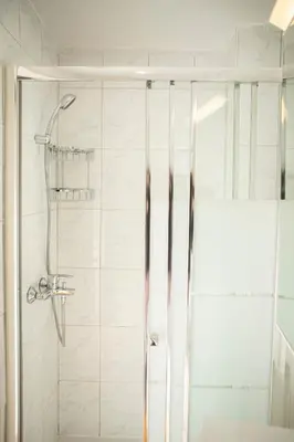 a shower with a glass door in a bathroom at Spacious studio located in the pedestrian zone in Nicosia