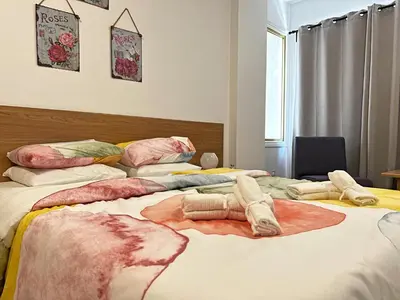 a bedroom with a large bed with towels on it at Albert's Apartment Center 21 in Larnaka