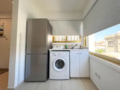 a kitchen with a refrigerator and a washing machine at Albert's Apartment Center 21 in Larnaka