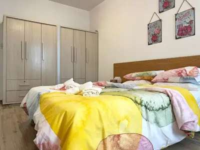 a bedroom with two beds with yellow and pink sheets at Albert's Apartment Center 21 in Larnaka