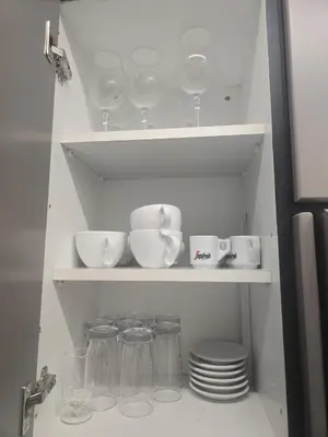 a shelf with dishes and cups and plates in a kitchen at Lazuli Urban Luxury -2 bedroom with Pool in Larnaka