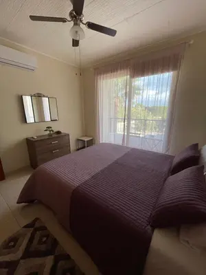 a bedroom with a purple bed and a window at Seascape apartment in Larnaka