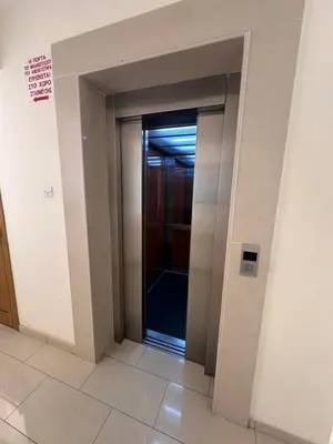 an elevator corridor with a glass door in a building at Seascape apartment in Larnaka