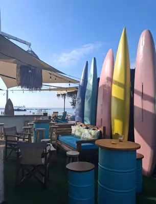 a group of surfboards lined up next to tables and chairs at Seascape apartment in Larnaka