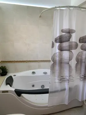 a bathroom with a bath tub with a shower curtain at Seascape apartment in Larnaka