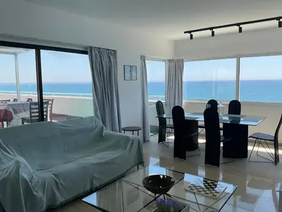 a living room with a bed and a table with chairs at Stunning Top-Floor Beachfront Apartment in Larnaka