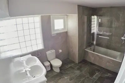 a bathroom with a toilet and a sink and a shower at Stunning Top-Floor Beachfront Apartment in Larnaka