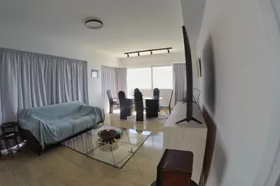 a living room with a couch and a table at Stunning Top-Floor Beachfront Apartment in Larnaka