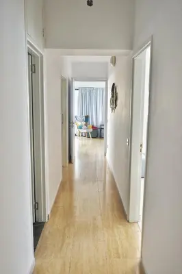 an empty hallway with white walls and wooden floors at Stunning Top-Floor Beachfront Apartment in Larnaka