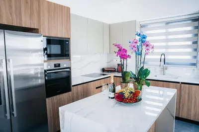 a kitchen with a bowl of fruit and flowers on a counter at TG NEW Luxury Private Resort & SPA Villas - Heated Salty Swimming Pool, Outdoor Jacuzzi, Sauna, Exotic Garden in Limassol