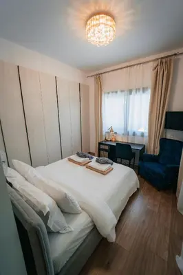 a bedroom with a bed and a chair and a chandelier at TG NEW Luxury Private Resort & SPA Villas - Heated Salty Swimming Pool, Outdoor Jacuzzi, Sauna, Exotic Garden in Limassol