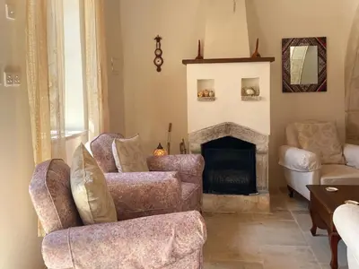 a living room with two chairs and a fireplace at Levanda House - Traditional House Vasa Koilaniou in Vasa Kilaniou